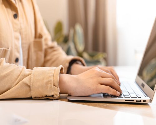 Person typing on laptop keyboard with good lighting