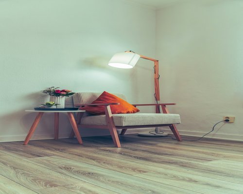 Cozy reading corner with warm lamp light next to a window